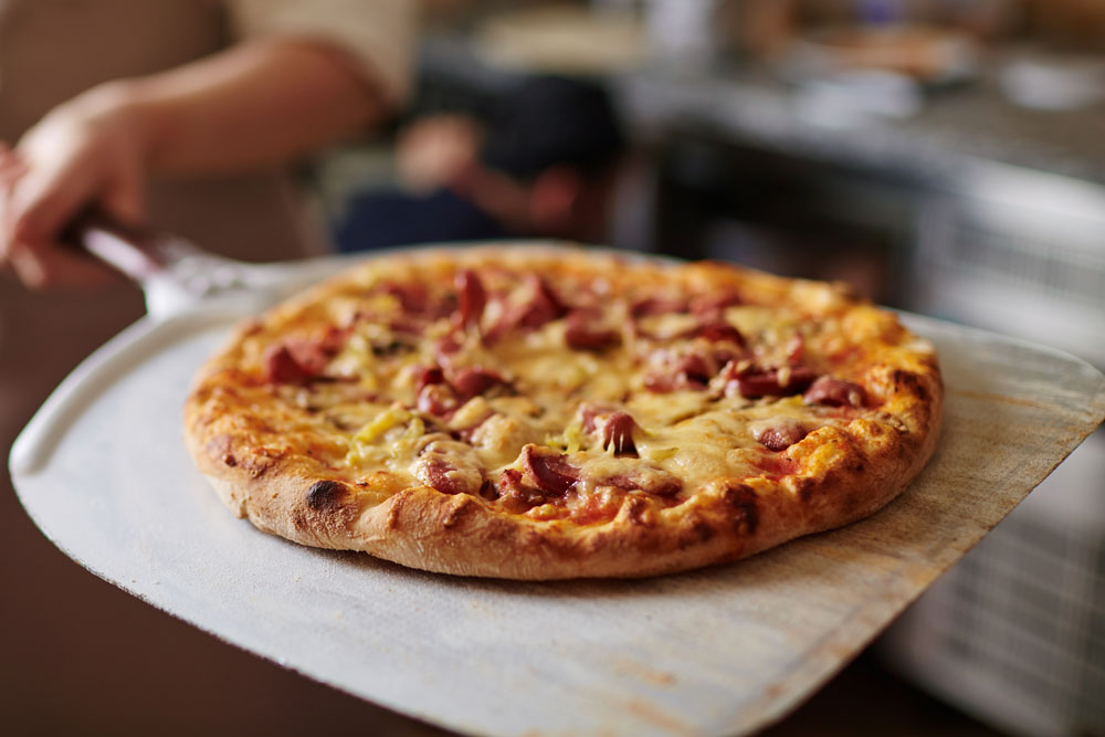 Cooked pizza served out of oven