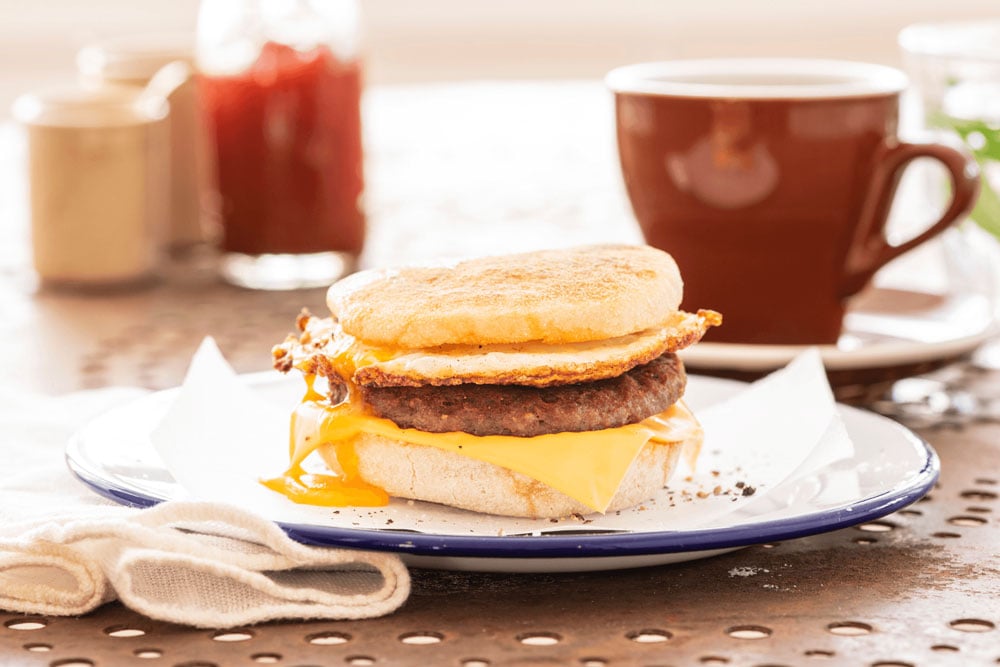 breakfast muffin with cup of coffee on table