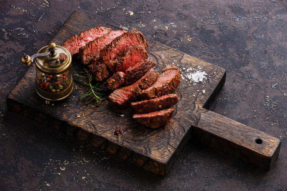 Cooked steak on rustic food board